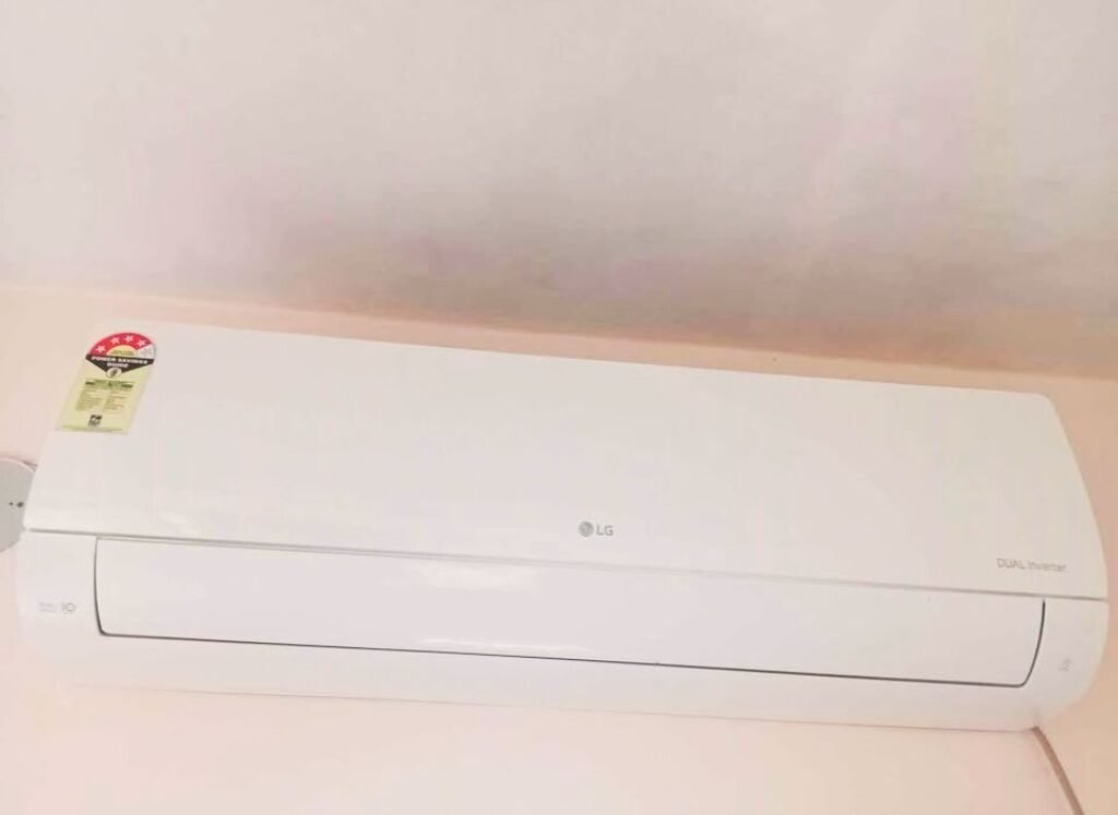 Close view of LG 1 Ton 4 Star AS-Q13JNYE wall-mounted air conditioner installed near the ceiling